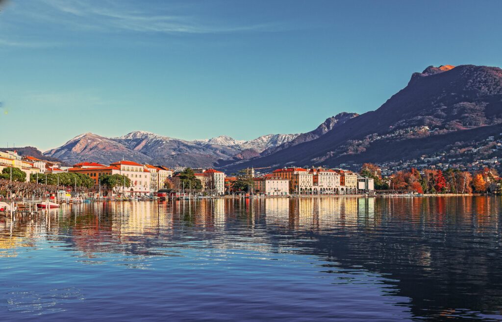 Picturesque coastal town with mountains reflecting in the tranquil lake waters.