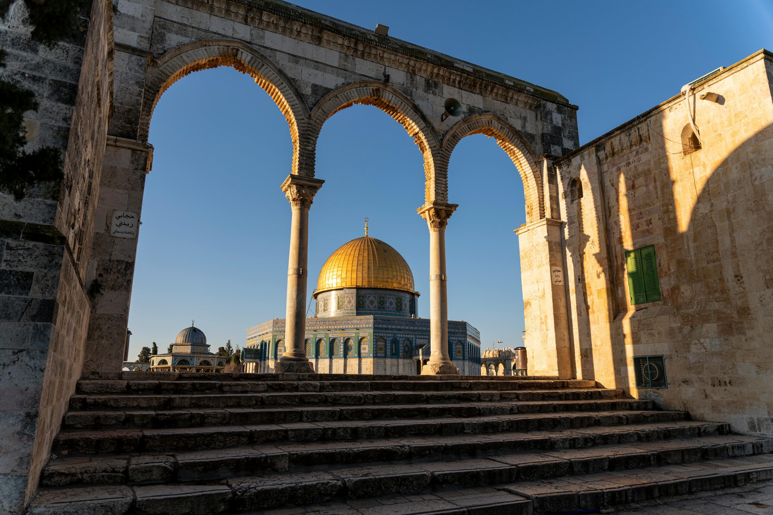 Beautiful view of the Dome of the Rock framed by arches in the Old City of Jerusalem.