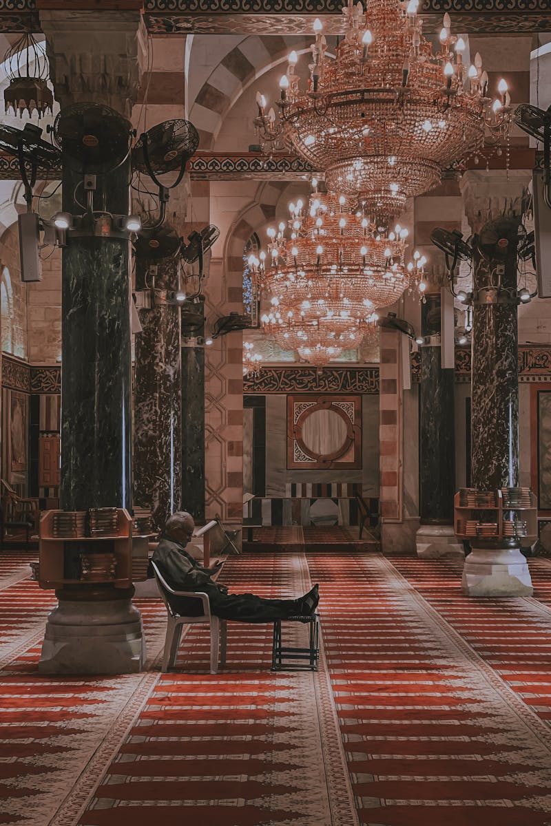 Peaceful interior view of Al-Aqsa Mosque showcasing chandeliers and marble columns.