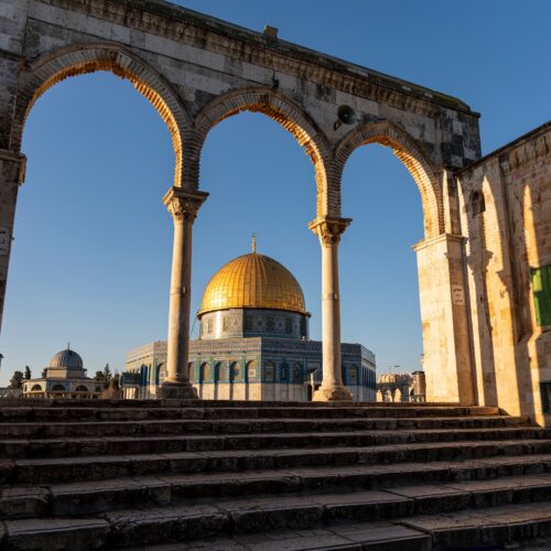 Beautiful view of the Dome of the Rock framed by arches in the Old City of Jerusalem.