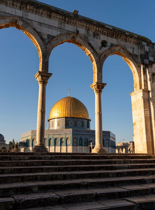 Beautiful view of the Dome of the Rock framed by arches in the Old City of Jerusalem.
