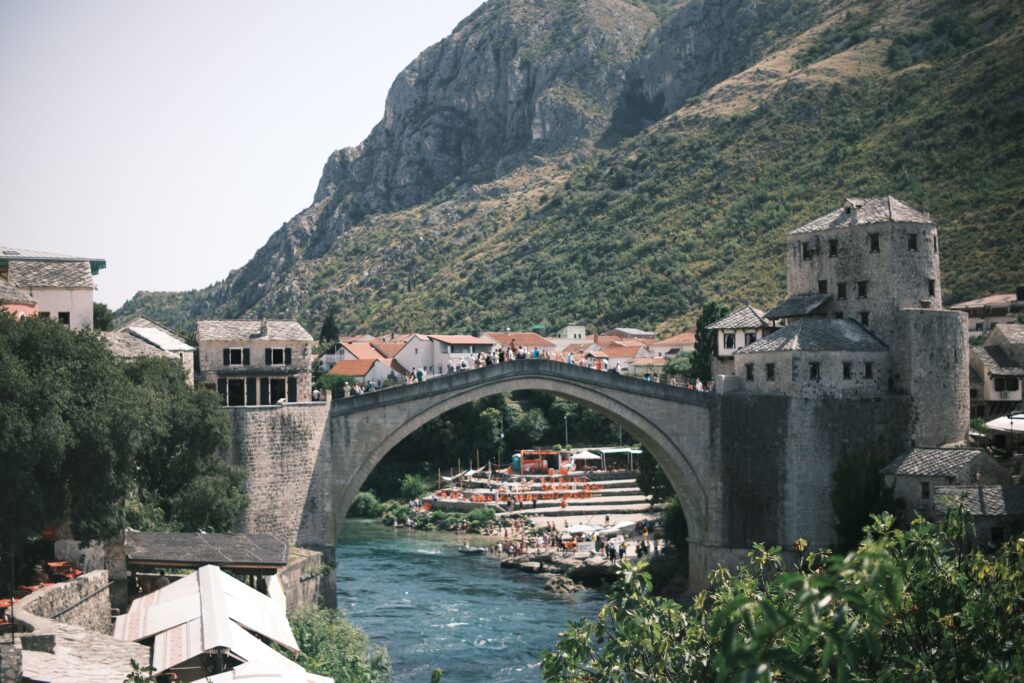 Scenic view of the Stari Most bridge in Mostar, Bosnia with surrounding hills.