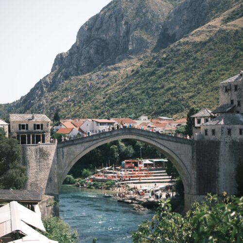 Scenic view of the Stari Most bridge in Mostar, Bosnia with surrounding hills.