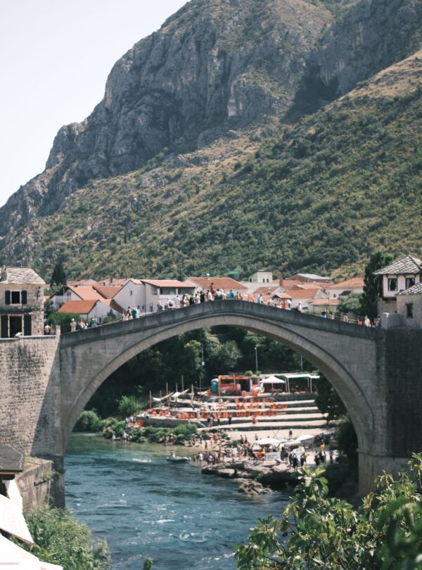 Scenic view of the Stari Most bridge in Mostar, Bosnia with surrounding hills.