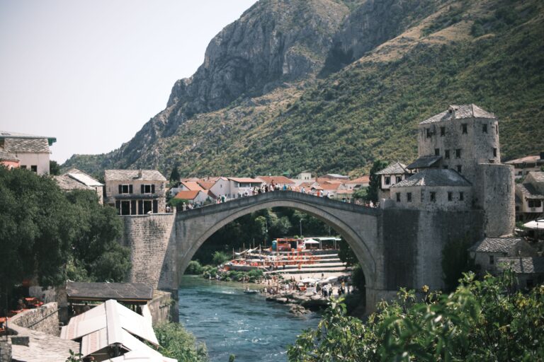 Scenic view of the Stari Most bridge in Mostar, Bosnia with surrounding hills.