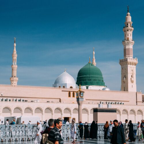 Urban view of Prophet's Mosque, Medina during day with minarets and people.