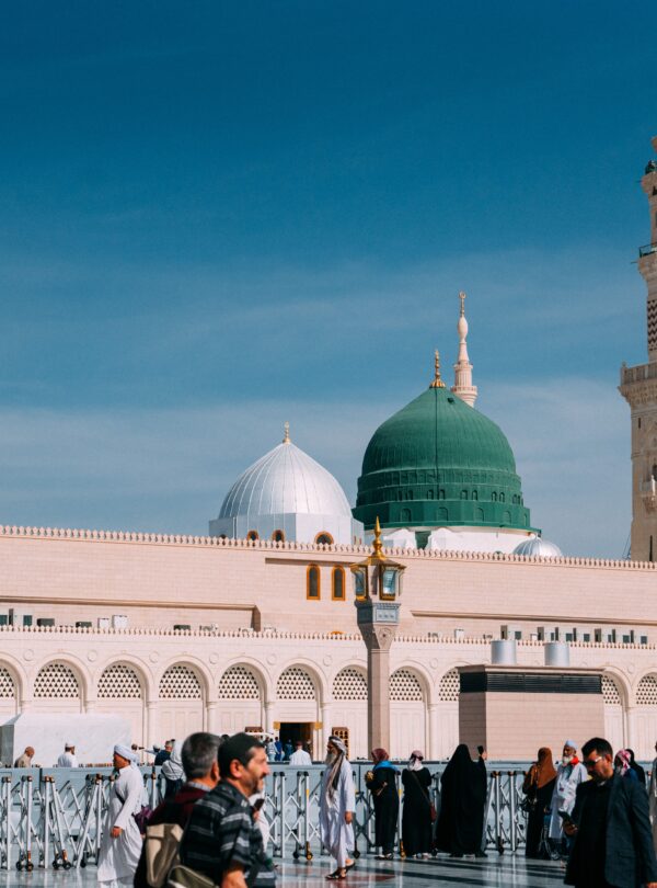 Urban view of Prophet's Mosque, Medina during day with minarets and people.