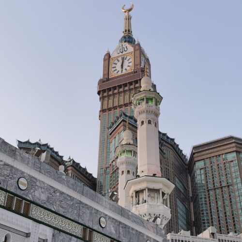 View of the iconic Abraj Al Bait and Mecca Clock Tower with surrounding architecture.