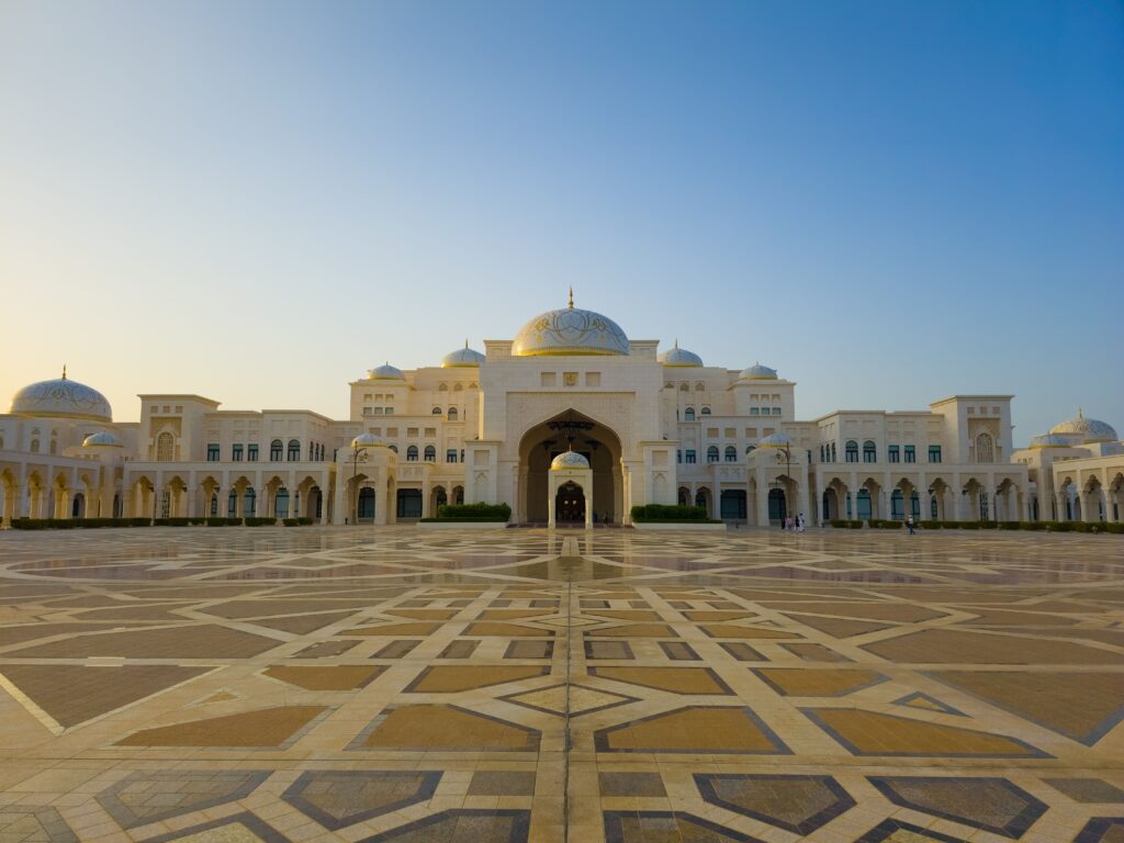 Stunning view of a grand Islamic architectural building with ornate domes at sunset.